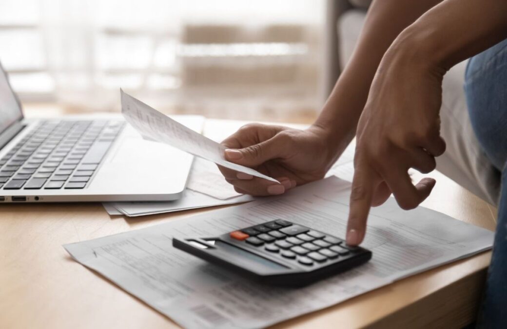 A business owner checking their notice of liability on a calculator.