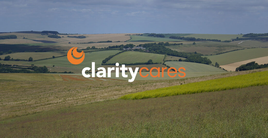 Clarity Cares logo on a landscape of green hills.
