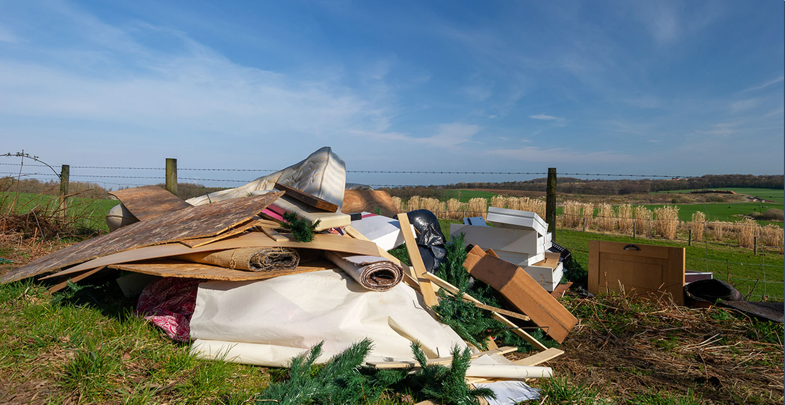 Fly-tipping in a field illustrating waste crime.